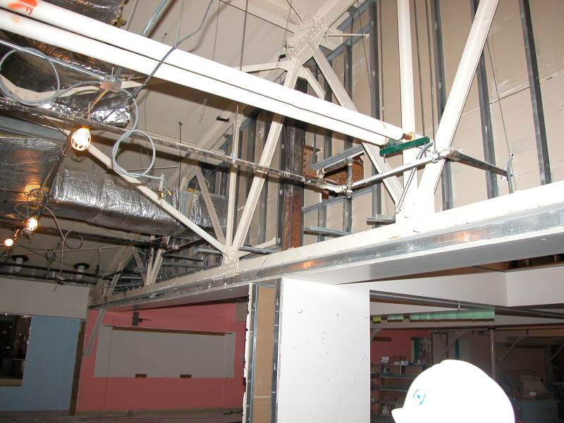 The curved roof of the old boy's gymnasium can be seen as the walls and ceiling are removed.