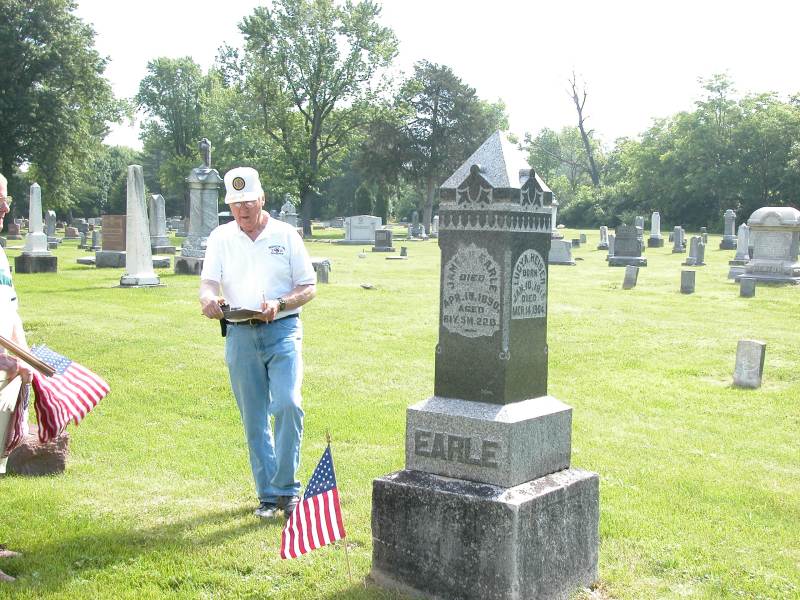George Kerr, past Commander of Post #3, checks the flag at James Earle's grave.