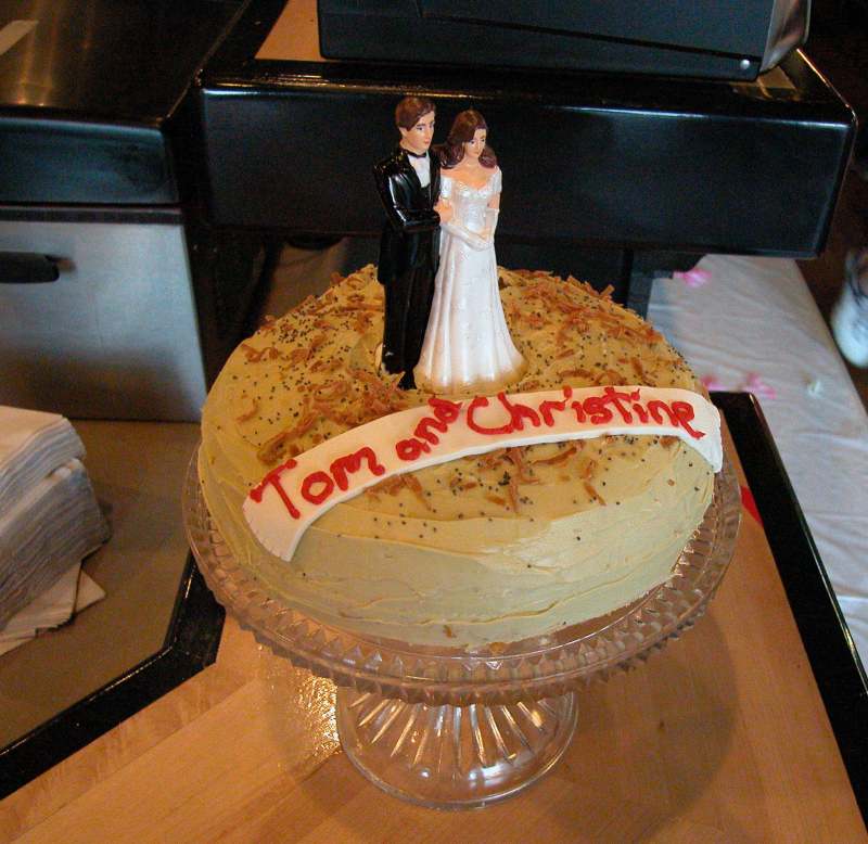 The bride and groom on a bagel cake. The cake was real cake that just looked like a big bagel.