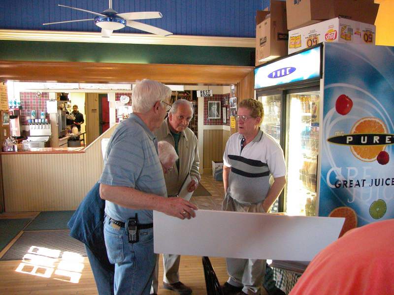 George Kerr (holding poster) and Bob Alloway (in front of cooler)