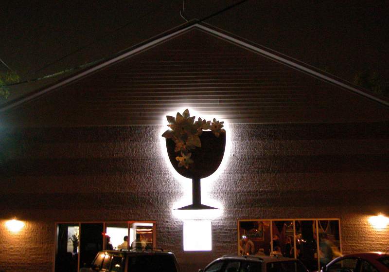 The large back-lit logo sign for the Brugge Brasserie glows on Westfield Boulevard.