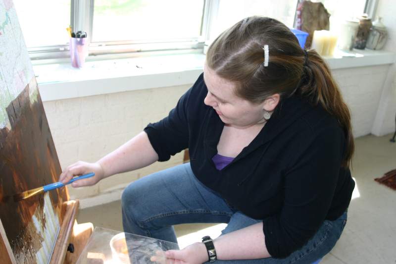 Kate Oberrich painting on her mother's porch.