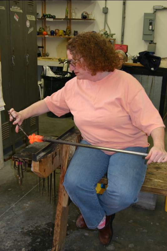 Joan Schneider working with the glass on the pipe.
