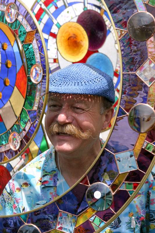Artist Jacques Bachelier of Nashville, Indiana, was kind enough to let us take his photograph looking through one of his larger stained-glass hanging pieces.