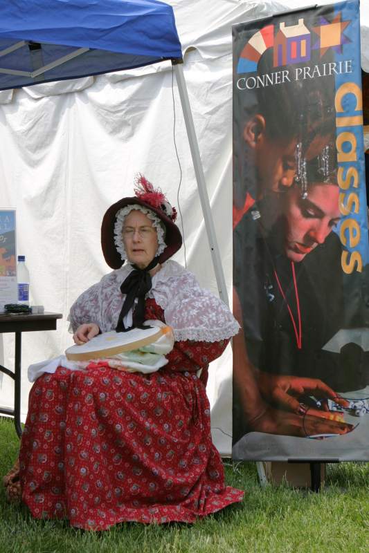 Carol Meeks stitched needlework in the Conner Prairie tent.