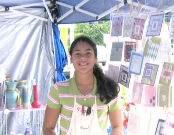 Keyona McElwain helped in her mother's tent selling artistic, hand-made cards.