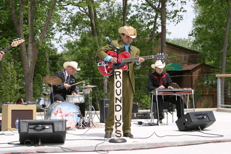 The Roundups performed on the Sculpting Court Stage. Joe Moran on drums, Jeff Stevenson on guitar, and Joe Alterio on pedal steel guitar. Dave Lawlis on bass guitar is in the picture to the left.