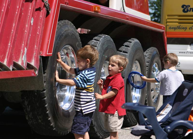 The enormous wheels of an IMI concrete truck attract an eager following at the 2005 Touch-a-Truck event.