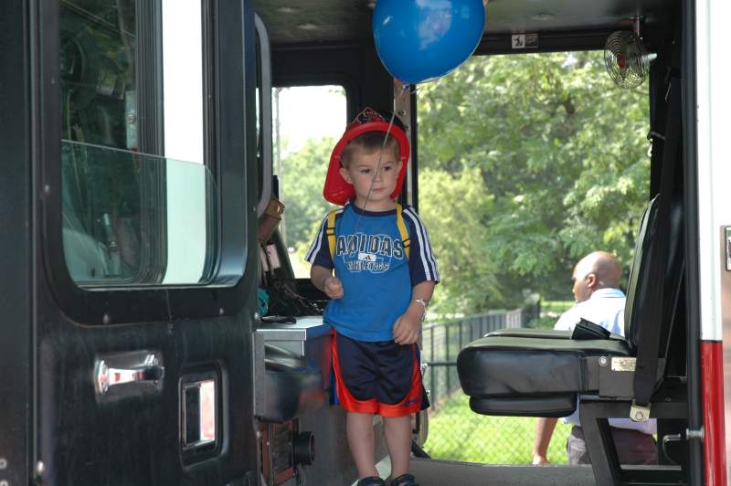 On a big fire truck with a balloon. Life is sweet!