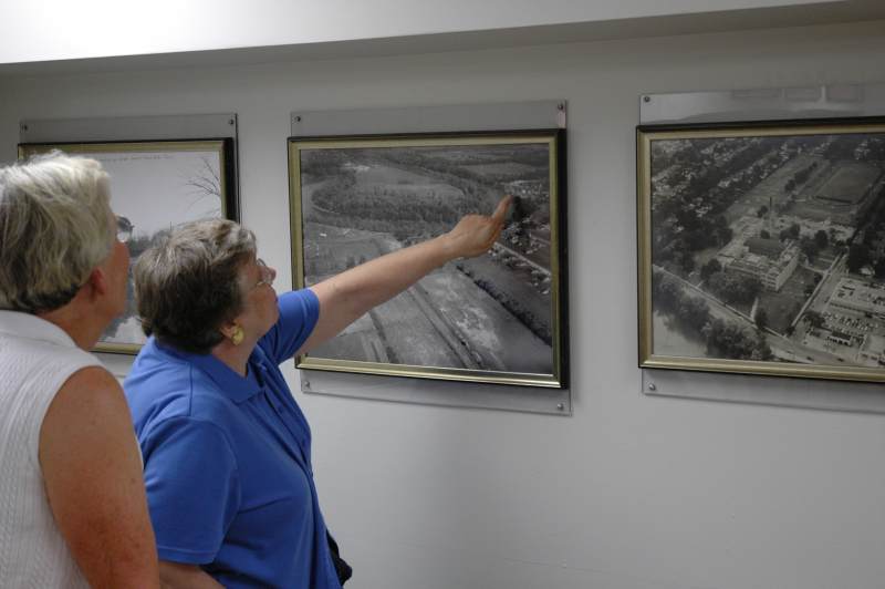 Two tour attendees discover an old aerial photo of Broad Ripple in the alumni center. The Broad Ripple Amusement Park can be seen in the corner of the photo.