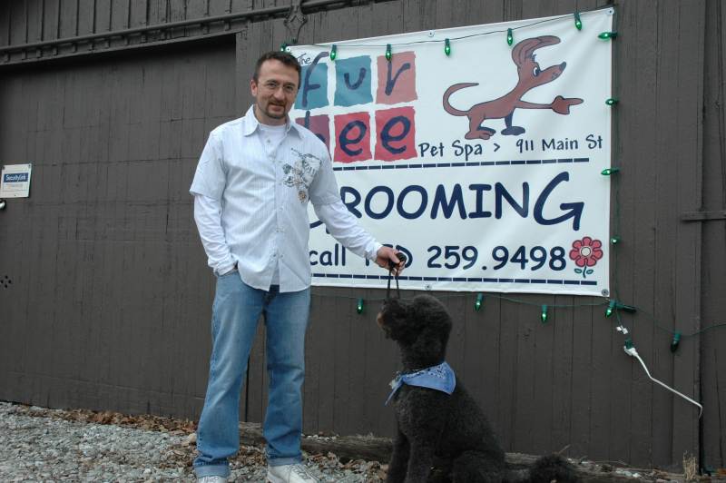 A view from Main Street: Fur-Bee owner Ted Lee and Ozzie stand in front of the store's display sign. For reservations call (317) 259-9498.