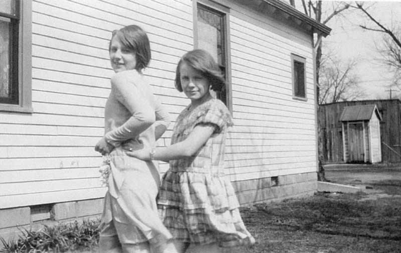 Evelyn (age 14) and Gladys (age 12) in 1930. Gladys pointed out the old out house in the photo. It was no longer in use in 1930, but remained in the back yard.