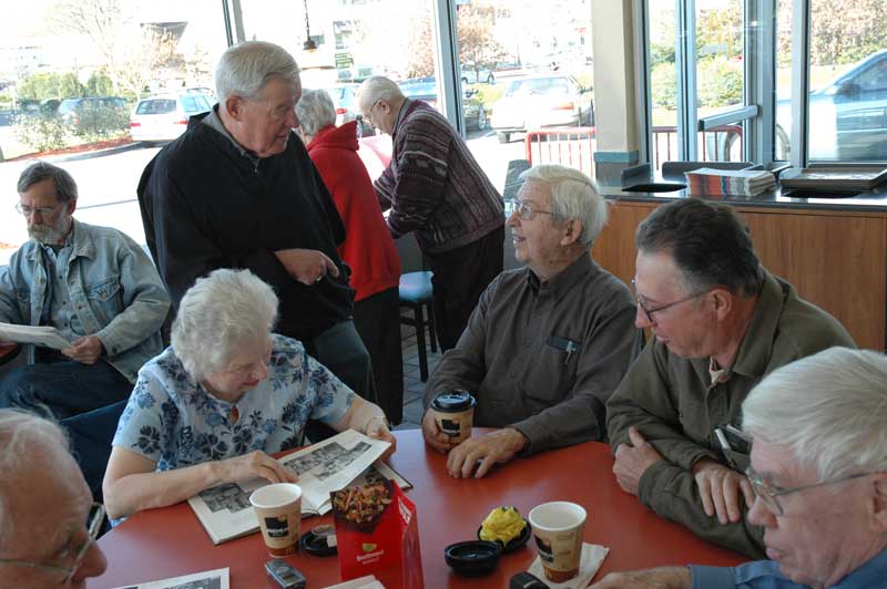 Hugh Wolf (standing) talking to Les Duvall (seated) about the Frank Baird Scholarship (Robert Hessong to Les's left).