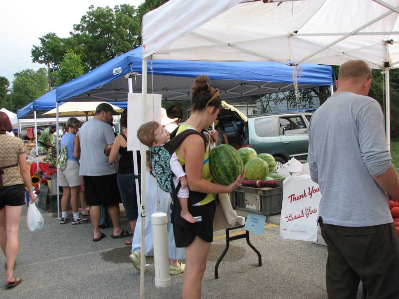 Did she buy the watermelon to balance her baby, or did she bring her baby because she knew she would be buying a watermelon? 