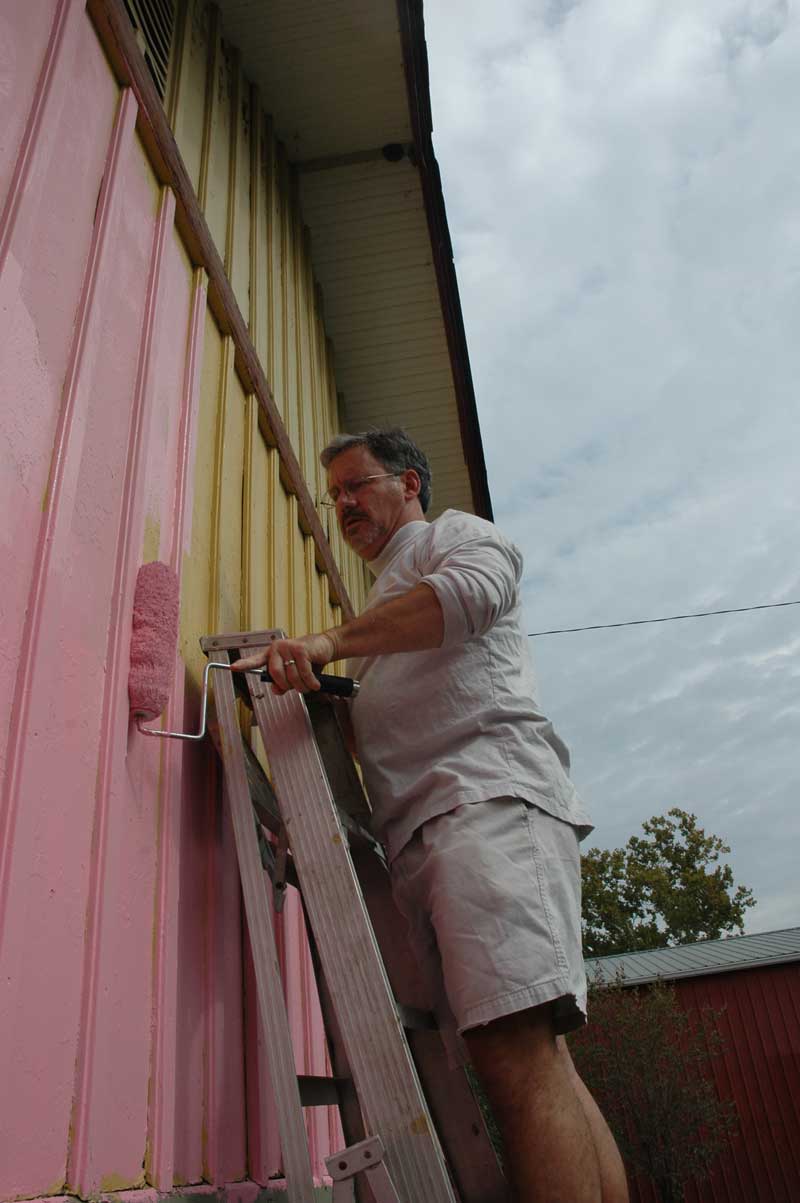 Bradford was out on both Sunday and Monday morning painting his half of the Whistle Stop bright pink and green.
