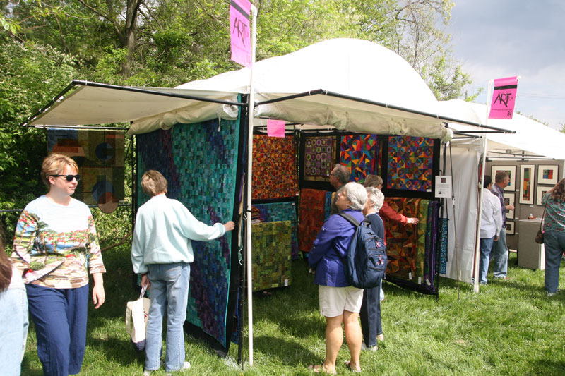 Art Fair visitors examining artists rugs at the 38th annual event on the grounds of the Indianapolis Art Center.