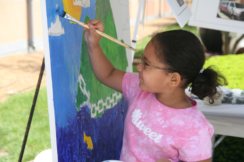 This young lady painted on one of the murals in the Art Center Outreach tent.
