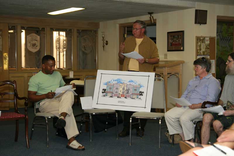 David Kingen (standing) showed the facade rendering for Keith Payne's (left) proposal for five condos at Birchwood and Kessler while neighbors listened.