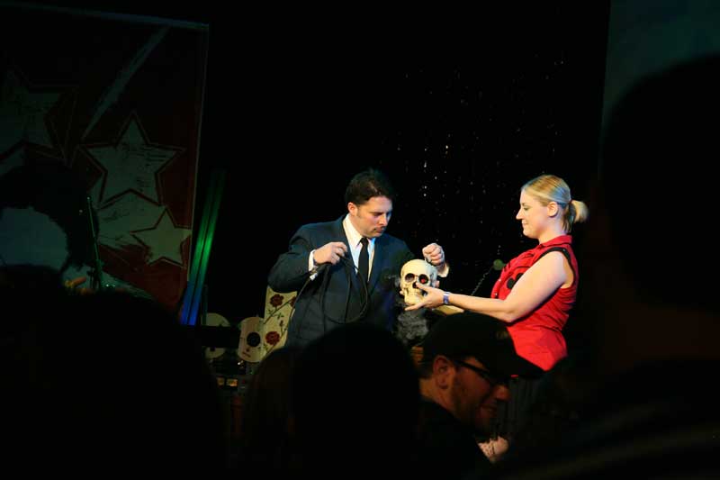 Mike Wiltrout draws a random canvas number from the scary skull presented by one of the Naptown Roller Girls.