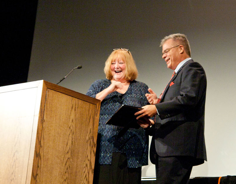 Principal Linda Davis presents 'Speed' Schumacher with the distinguished alumni award.