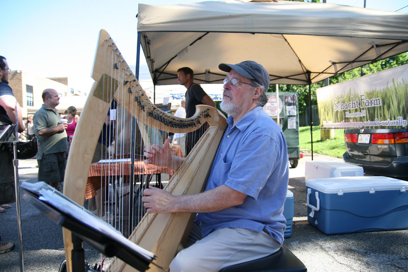Tom Duncan at the north end of the market playing harp.