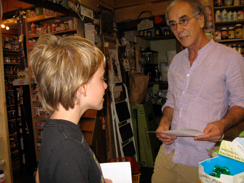 Mason Perry explaining duck flyer to Bob Bennington at Good Earth.