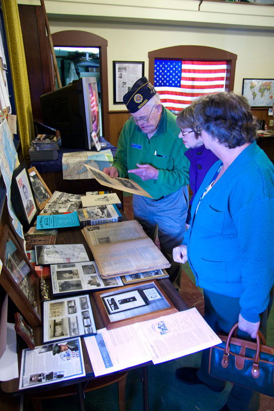 Post member Robert McGuire looking through a WWII scrapbook