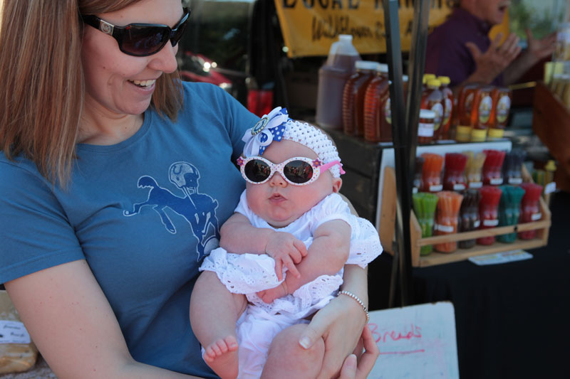 Little Gabriella shades her eyes from the bright sunshine during her first visit to the market.