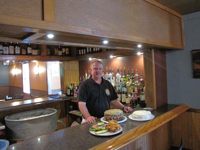 JT's Grille & Bar owner Tim Paxson with their Pork Tenderloin, German Chocolate Cake and Red Velvet Cake.