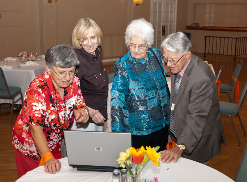 Rosemary Draga (47), Lorraine Mullendore (48), Jane King (40) and Alex Christ (40) looking at the photos from the 2011 reunion