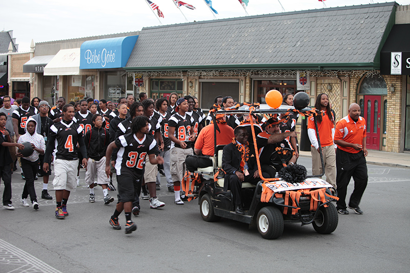 Michael T. Akers, Principal of Broad Ripple Magnet High School for the Arts and Humanities leads the football team in the parade.