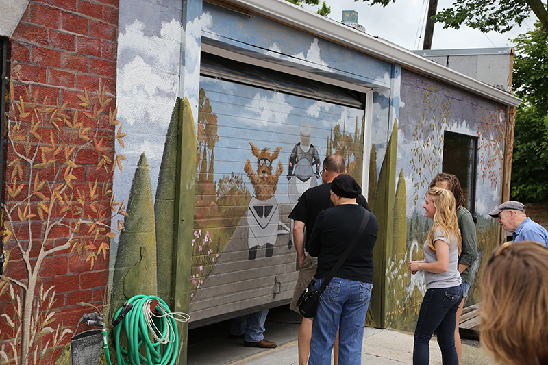 Fair attendees admiring a mural at Gina Rosenow Decorative Art