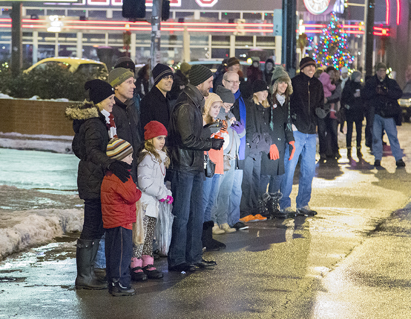 The Hueni family watches the parade next to Chad Fallis