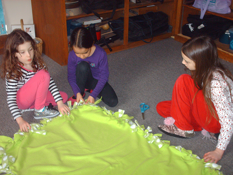 Montessori School students work on a blanket for Project Linus.