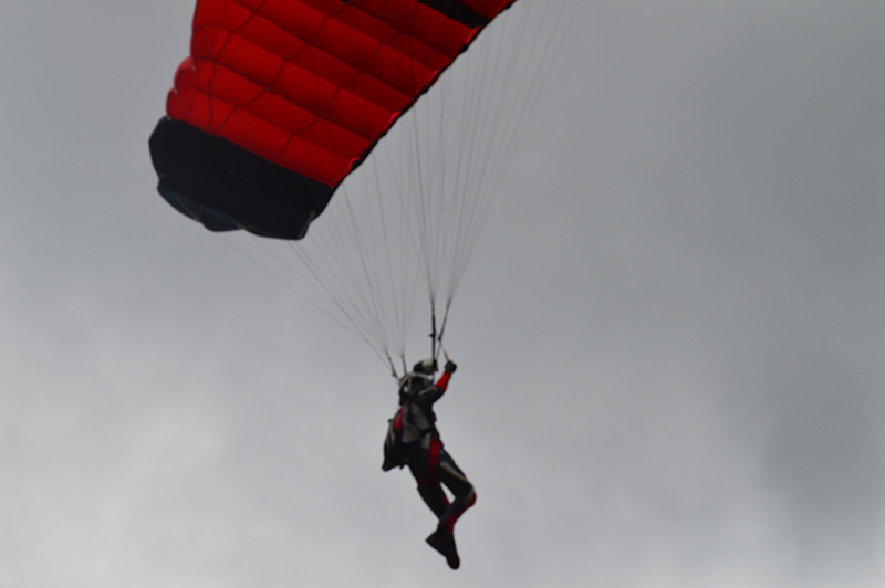 The photo was taken by Scott Estrada. It is of one of three skydivers who jumped from a small plane at 2000 feet and landed in the middle of Opti Park amid the spectators and cars.
