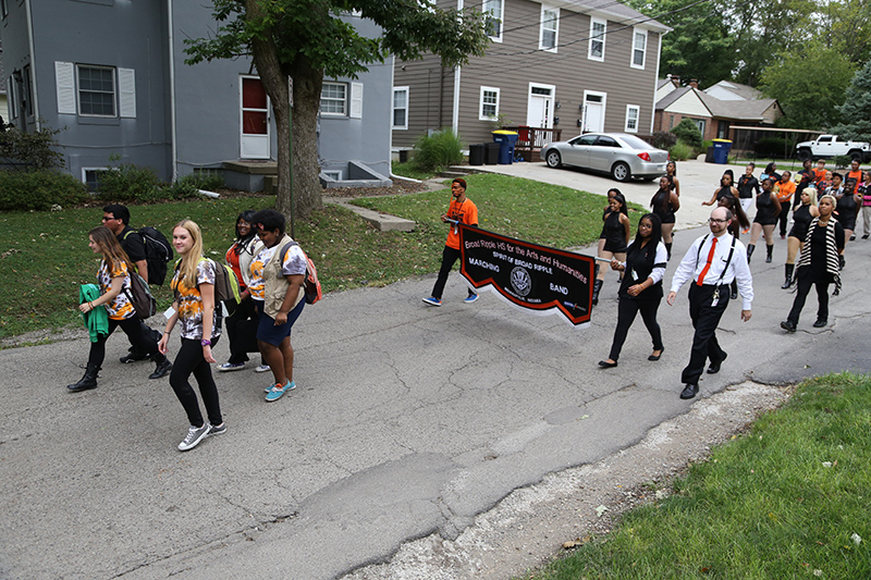 Assistant Band Director John S. Hague leading the marching band down 61st Street.