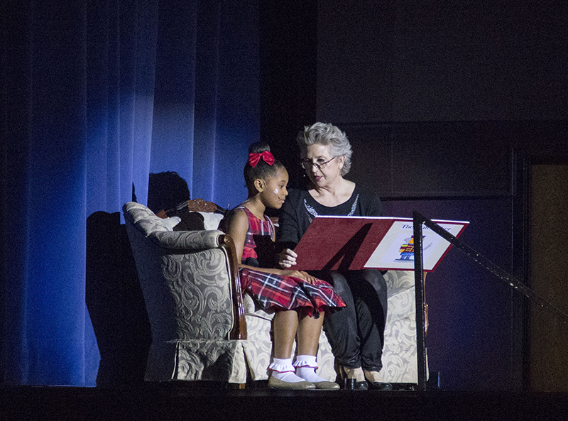 Therese Chatelaine reads the story of the Nutcracker to Gabriella Hargro as the ballet is performed