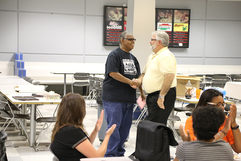 Outgoing Principal Mike Akers (right) congratulates outgoing Vice Principal Keith White.