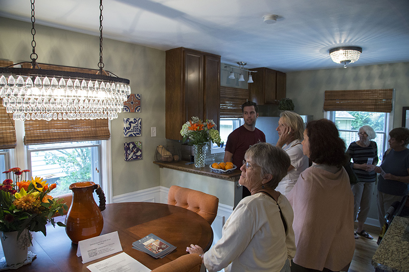 Tour goers examine a chandelier in the kitchen at 6042 Crestview Avenue
