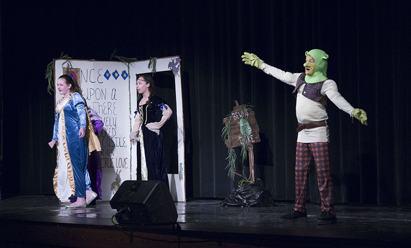 Storytellers (Caroline Smith, McKinley Tolliver and Emma Szalkie) and Shrek (Henry DeRyke) in the opening scene.