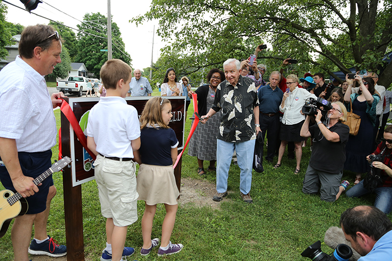 Dan Wakefield (wielding scissors), with (L to R) Pat, John, and Adele Chastain cut the ribbon as dozens of cameras recorded the event.