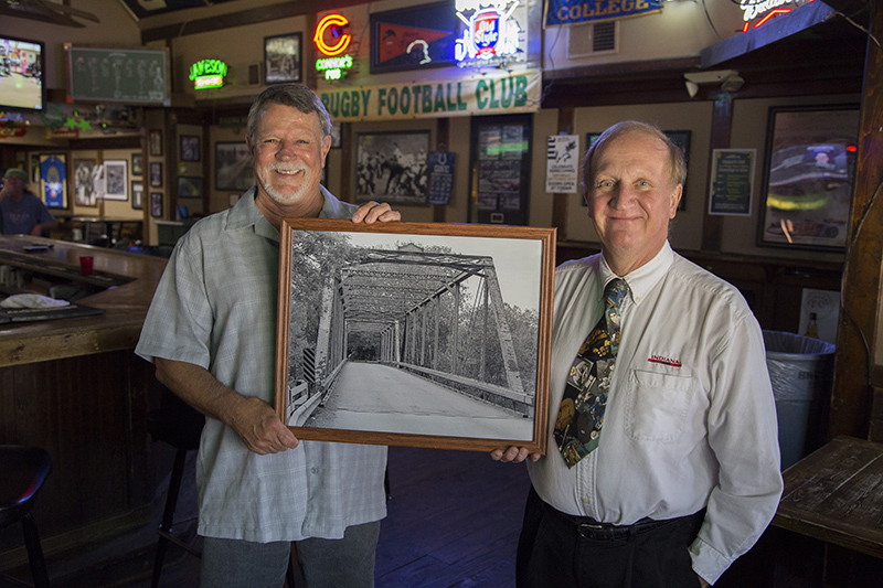 Tim Micheli and Dennis Boone at Connor's Pub holding an enlargement of the bridge.