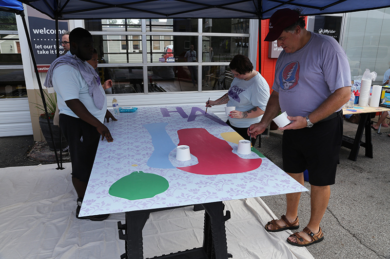 Steve Sanner (red cap), owner Jiffy Lube, working on the mural.