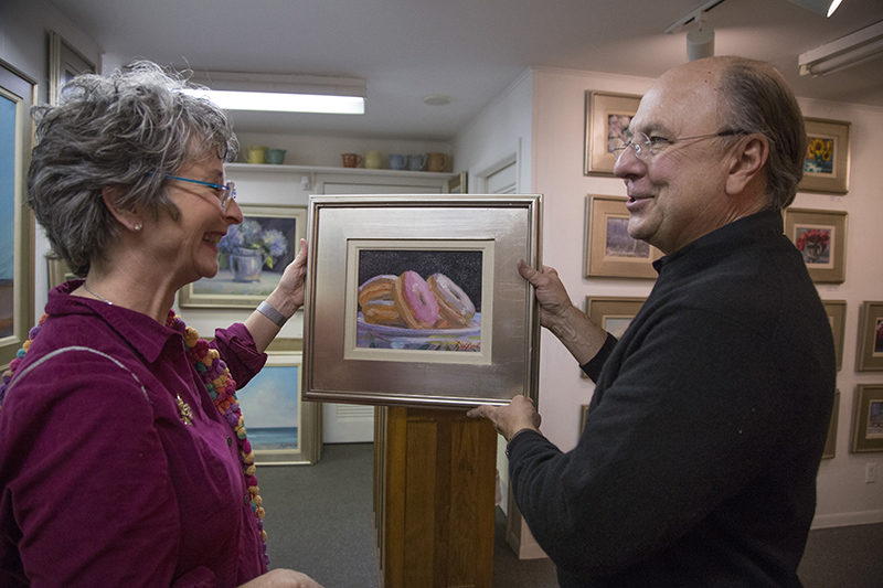 Douglas showing his line of donut paintings to Nancy Beck