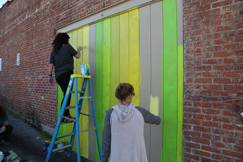 Megan Jefferson and Jamie Locke painting the Angel Wing mural on the northeast corner of The Bungalow, 924 E. Westfield Boulevard.