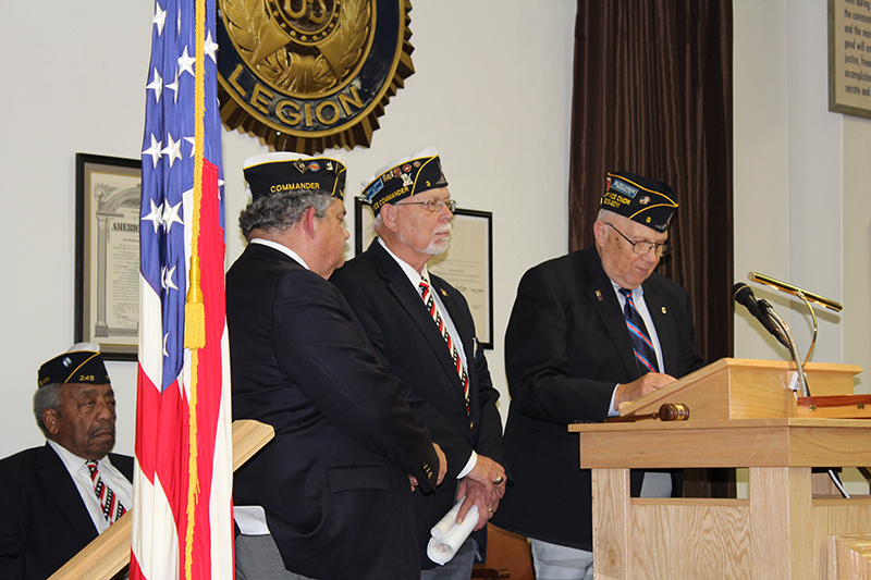 Skip Nunweiler explains the duties and responsibilities of office of the District 11 Commander to the newly installed Commander Rees Morgan as previous Commander Tim Elson looks on.