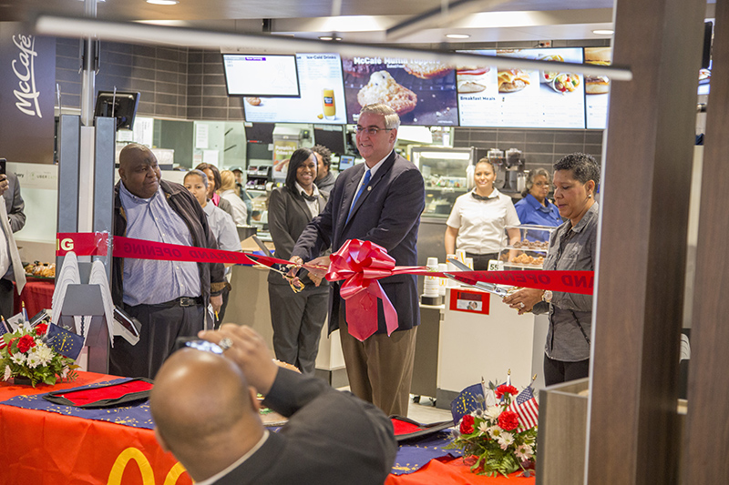 Reginald Jones, Governor Eric Holcomb, and Tracey Jones cut the ribbon at the Broad Ripple McDonald's