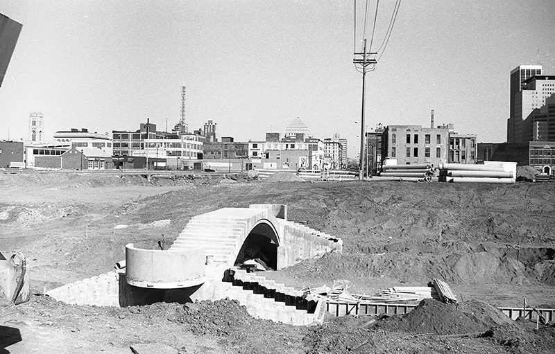 Taken during the canal reconstruction around 1988, this is looking east from the new Vermont Street walking bridge. The World War Memorial is visible in the back.