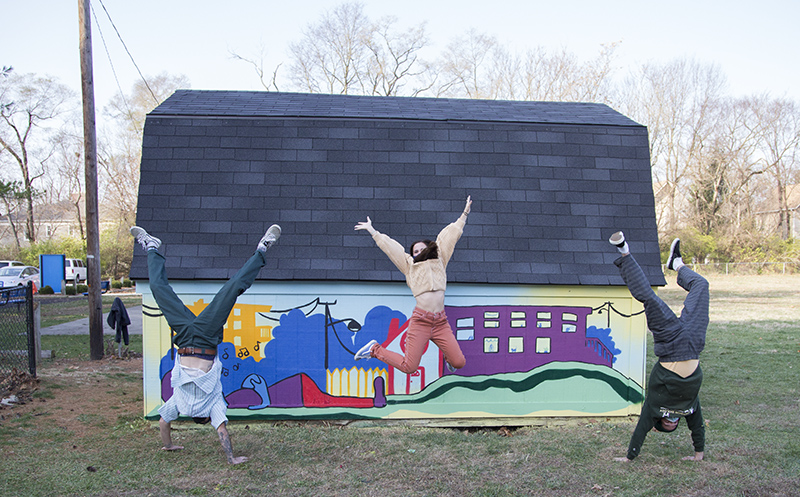 The artists in front of their mural