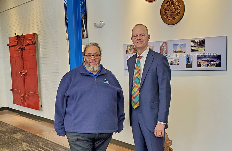 Bruce Buchanan (right), CEO and fourth generation owner of Flanner Buchanan, and Brandon Cosby (left), Executive Director of Flanner House, are shown celebrating Flanner Buchanan's donation of land use for three greenhouses for Flanner House. Flanner Buchanan's 140th anniversary was on March 8 at its corporate headquarters located at 2020 Montcalm Street in Indianapolis' Riverside neighborhood. Frank W. Flanner was a founder of Flanner House in 1898.